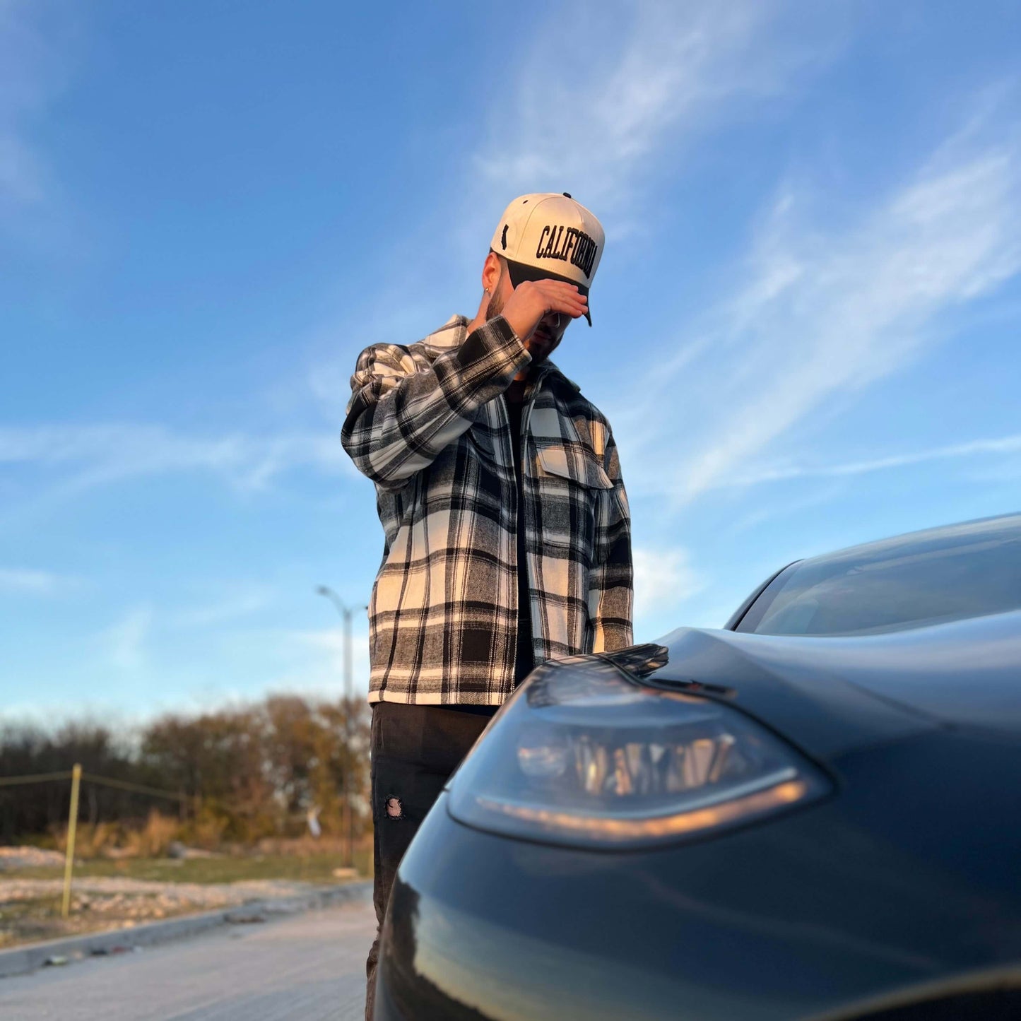 Model Wearing California Off White Snapback – Posing in Flannel Shirt with Car Background