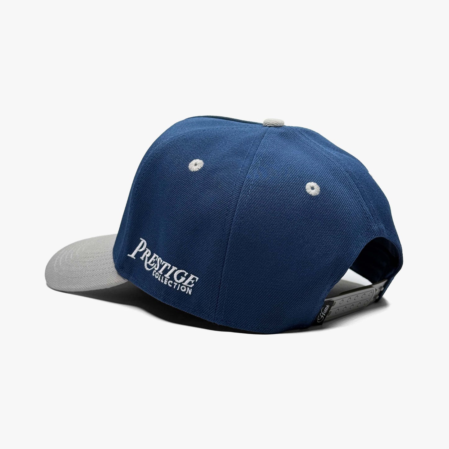 Back view of navy Dallas snapback hat with adjustable strap and Prestige Collection tag