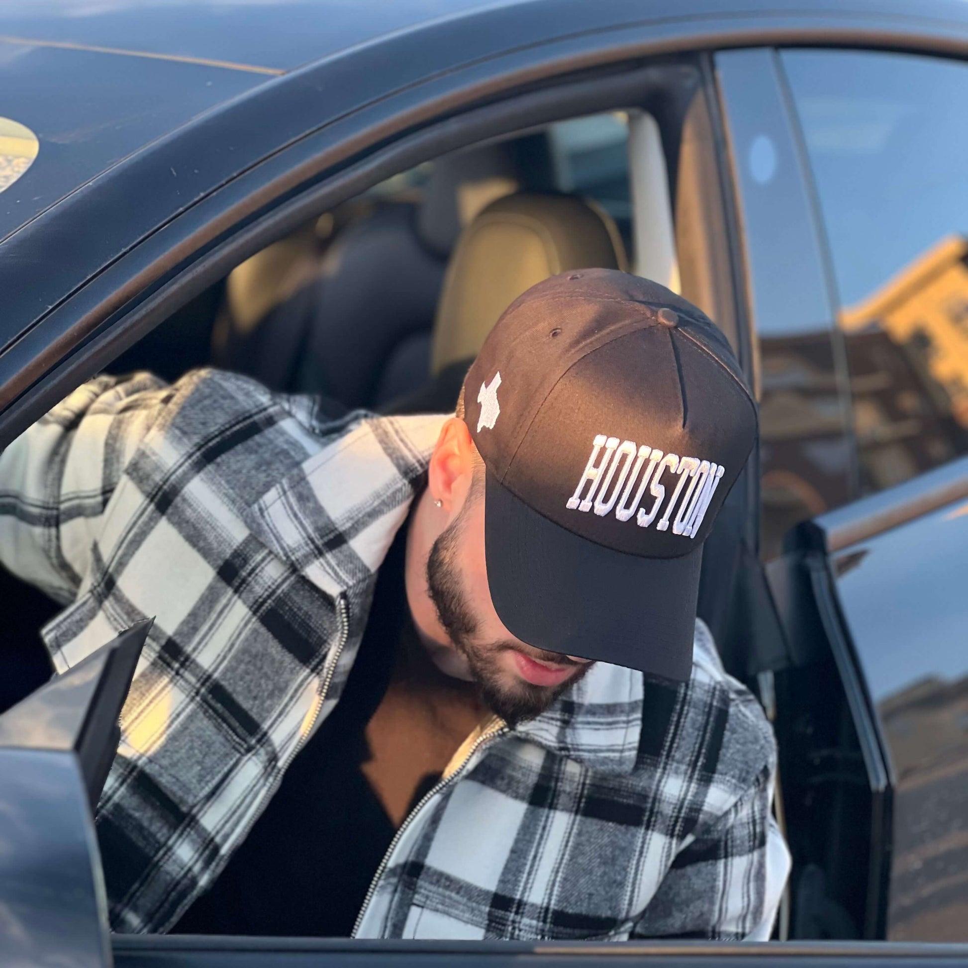 Model adjusting Houston Black Snapback Hat while exiting vehicle