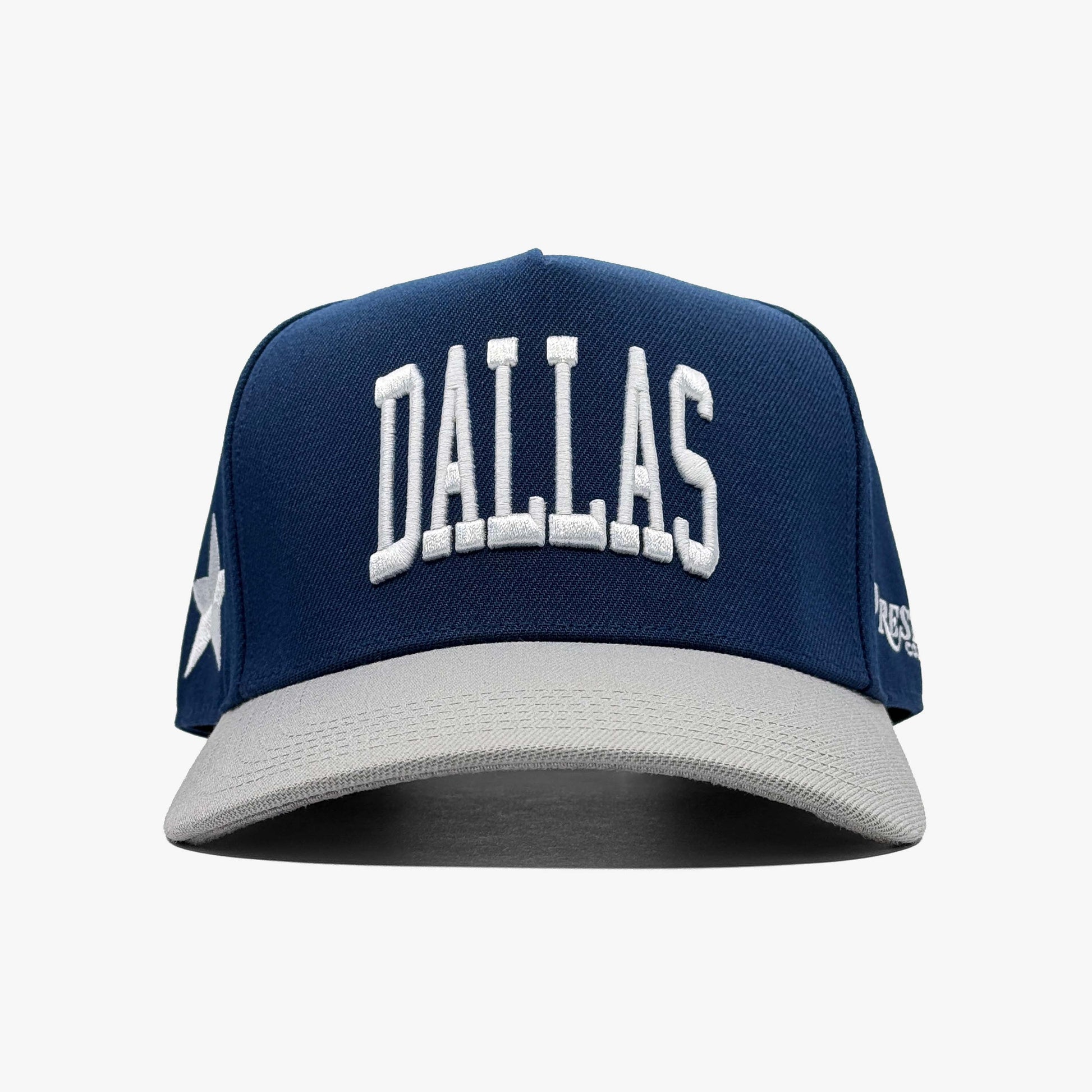 Navy and grey Dallas snapback hat with white embroidered "Dallas" wordmark and star logo